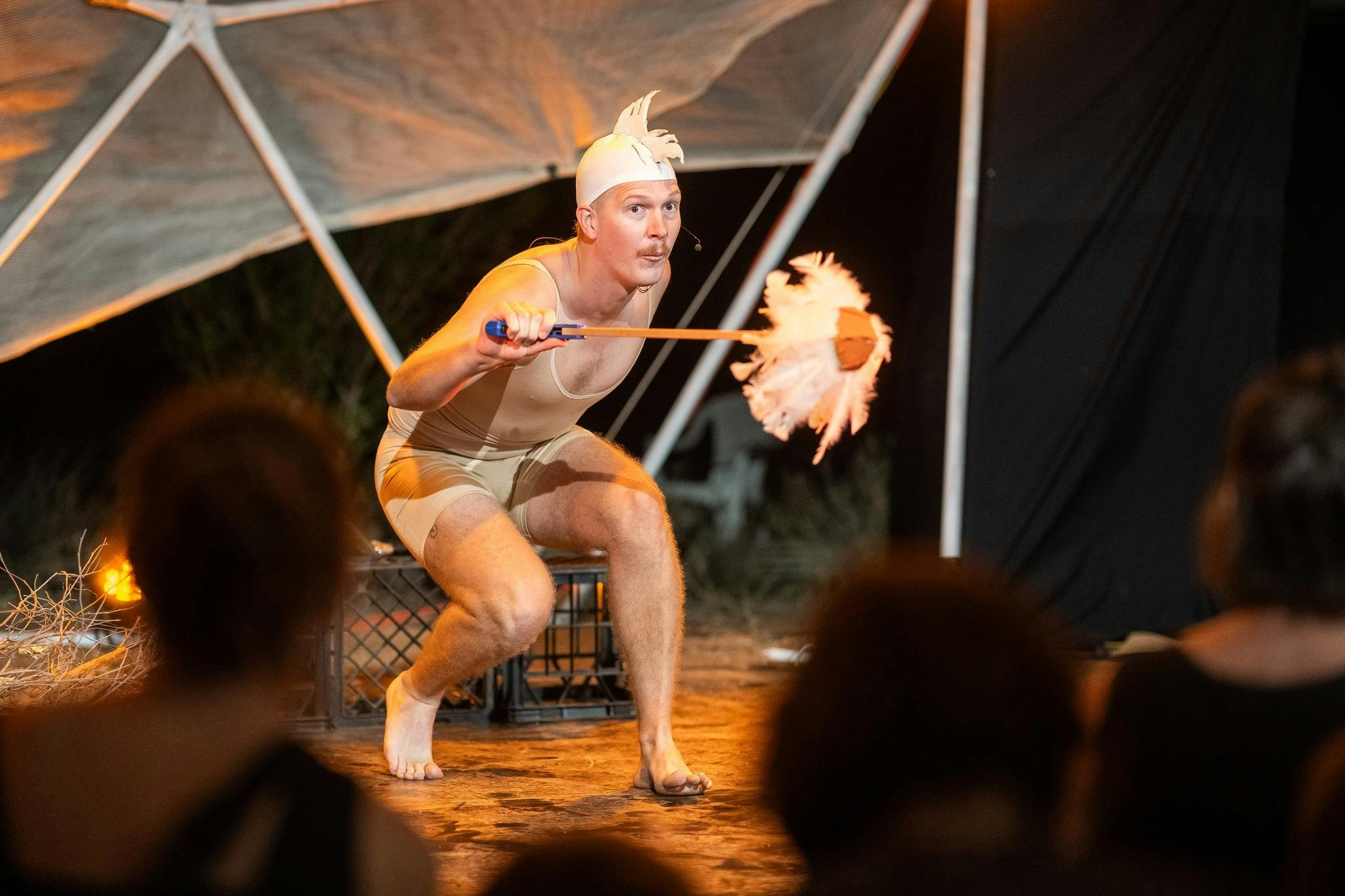 Performer on stage dressed as a chicken before audience members