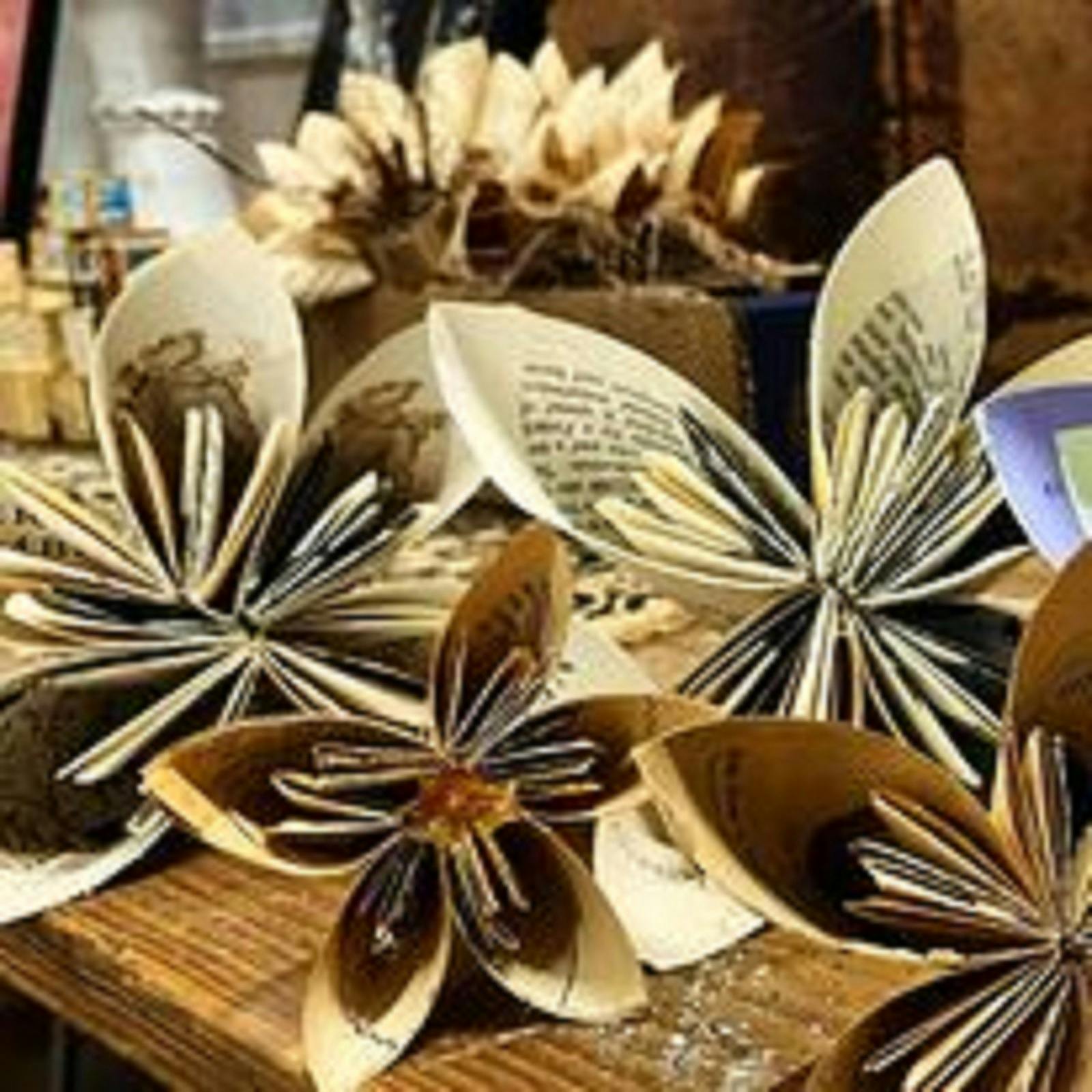 Artistic cleverly folded printed book paper like little umbrellas that look like flowers.