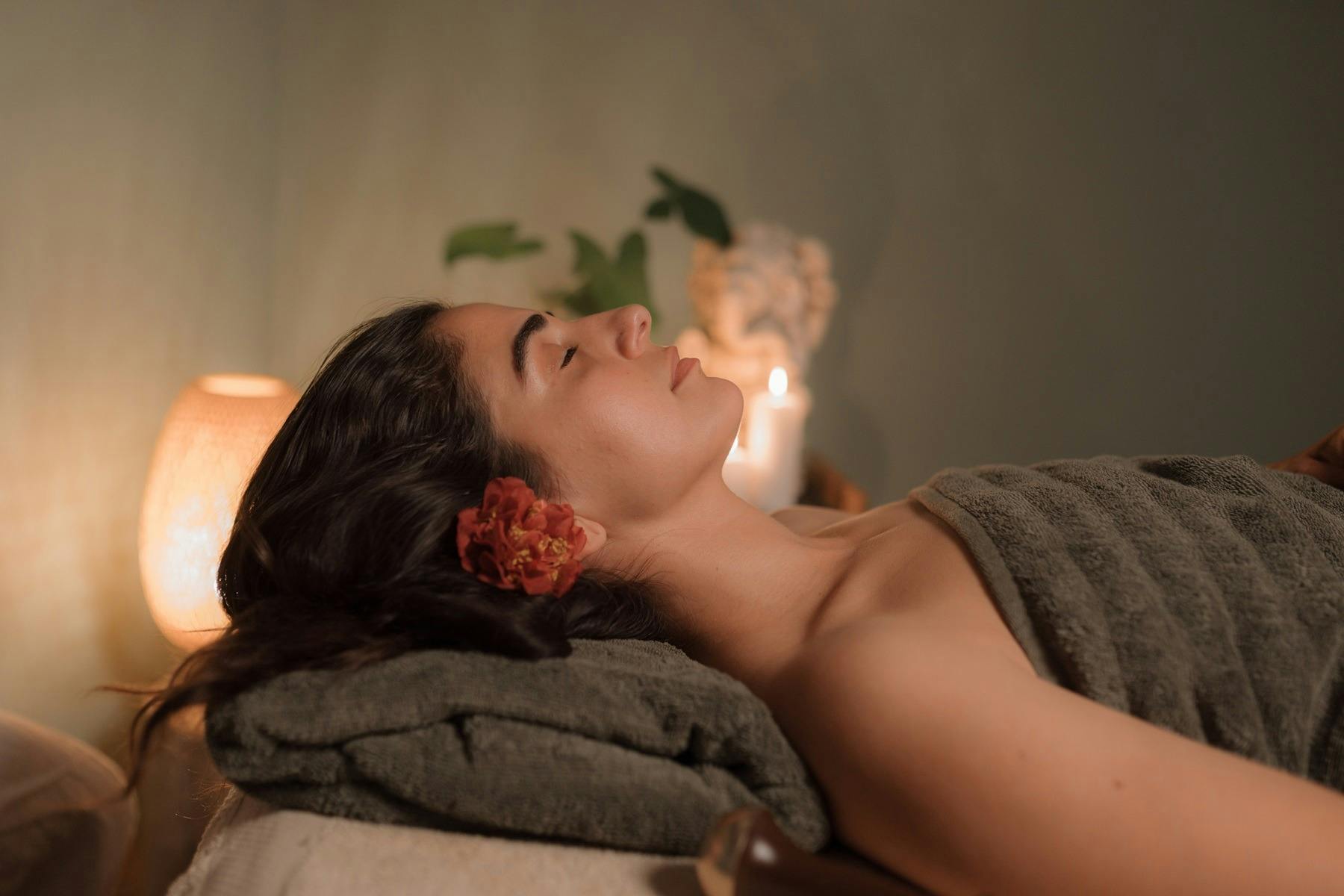 편안한 마사지를 받은 후 한 여성이 평온한 표정으로 마사지 테이블에 앉아 있습니다.