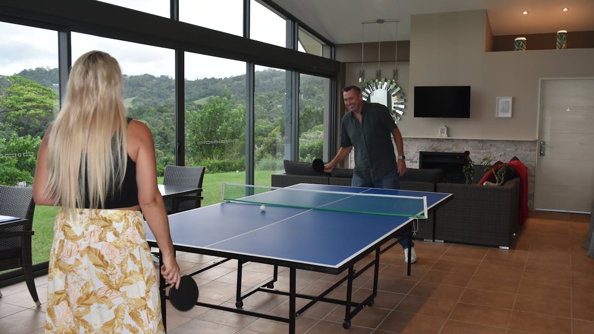 A couple enjoying a game of Table Tennis in the Guest Lounge Room