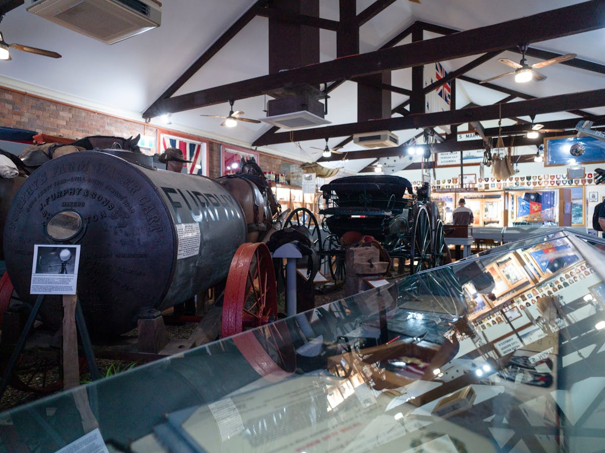 Photo inside MaryboroughMilitary Museum showing old items such as a Furphy water carrier from WW1