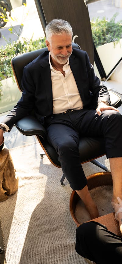 A client enjoying a Executive Pedicure at FANAEIANS Barber & Spa