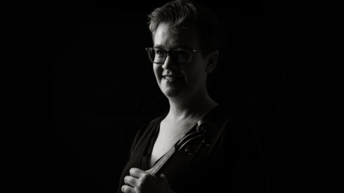 Black-and-white portrait of a violinist in profile, looking toward the light