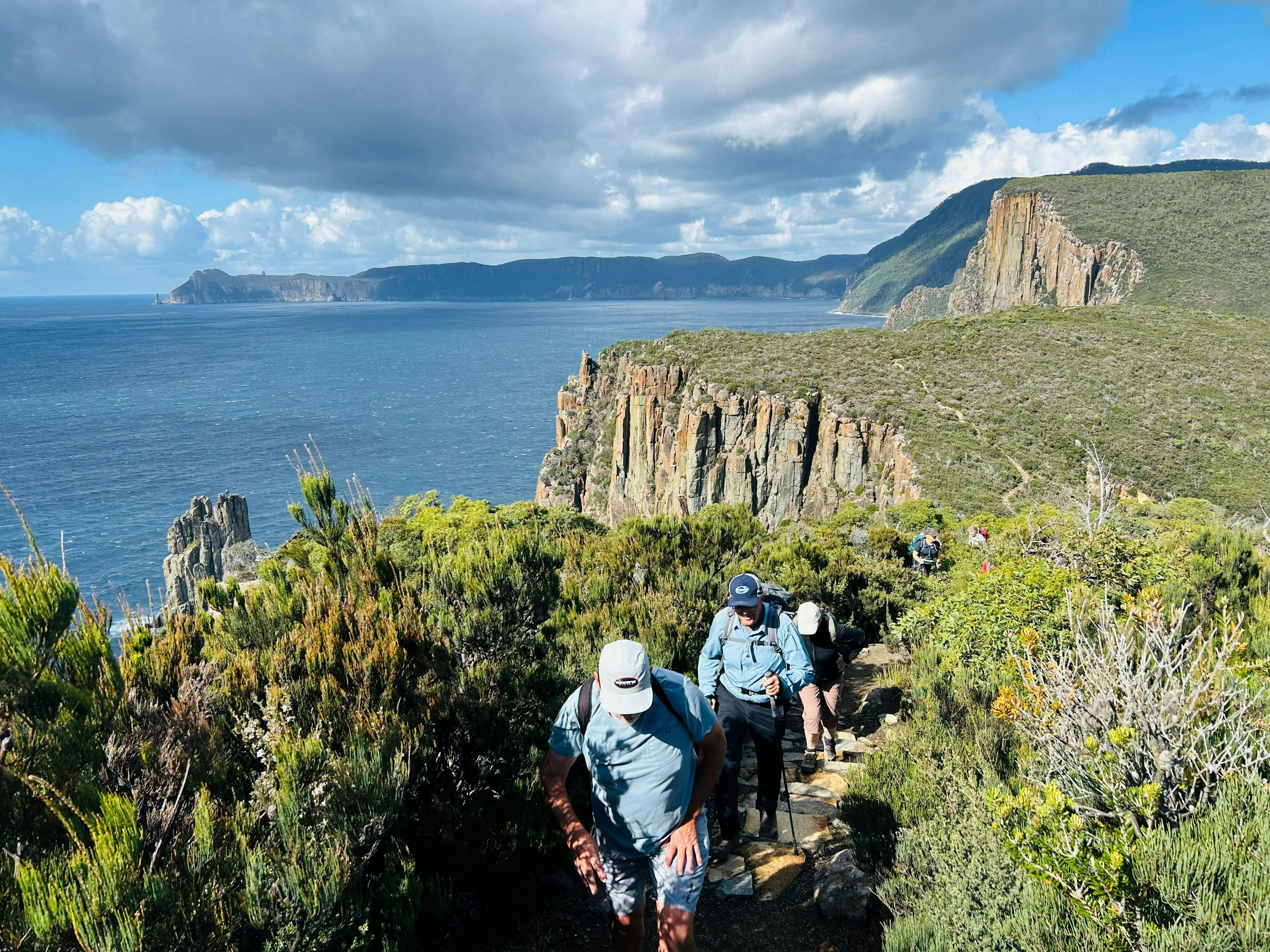 Group of walkers on a guided Three Capes Walk Tasmania hiking coastal trail with ocean views