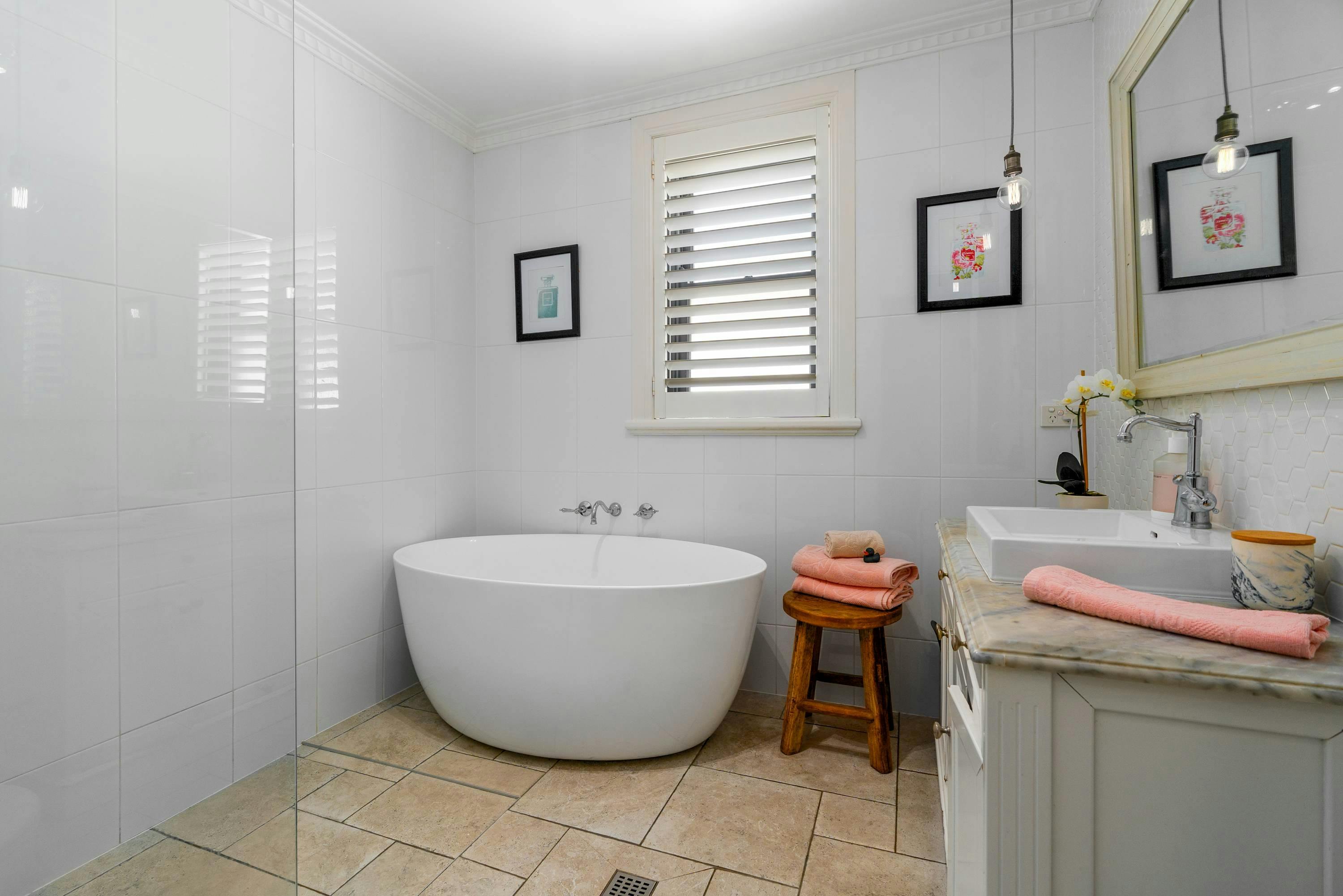 Main Bathroom with bathtub, open shower and vanity.