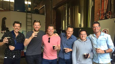 Happy men with beers on a brewery tour