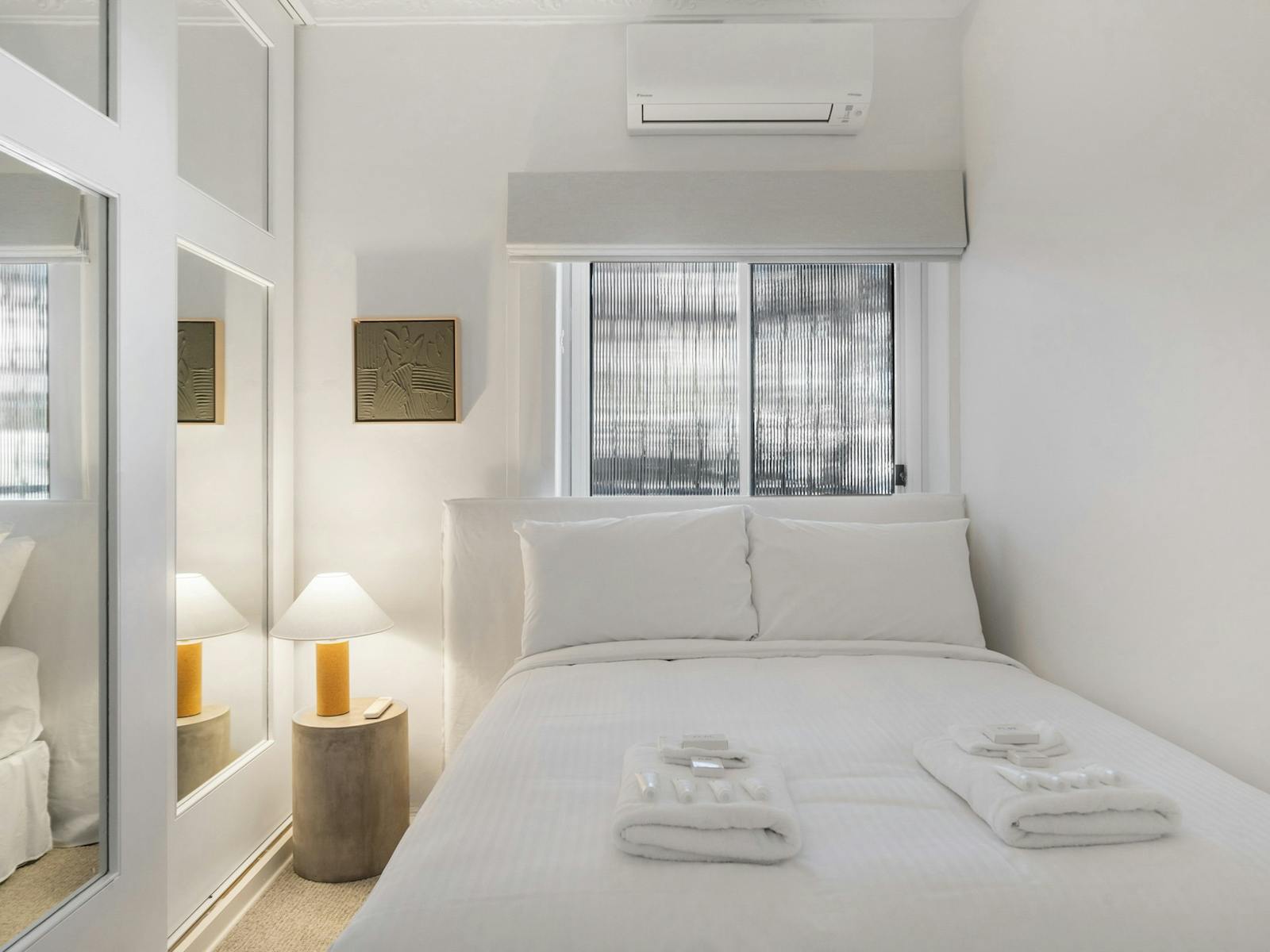 Cozy bedroom with white bedding and unique decor in a quiet setting.