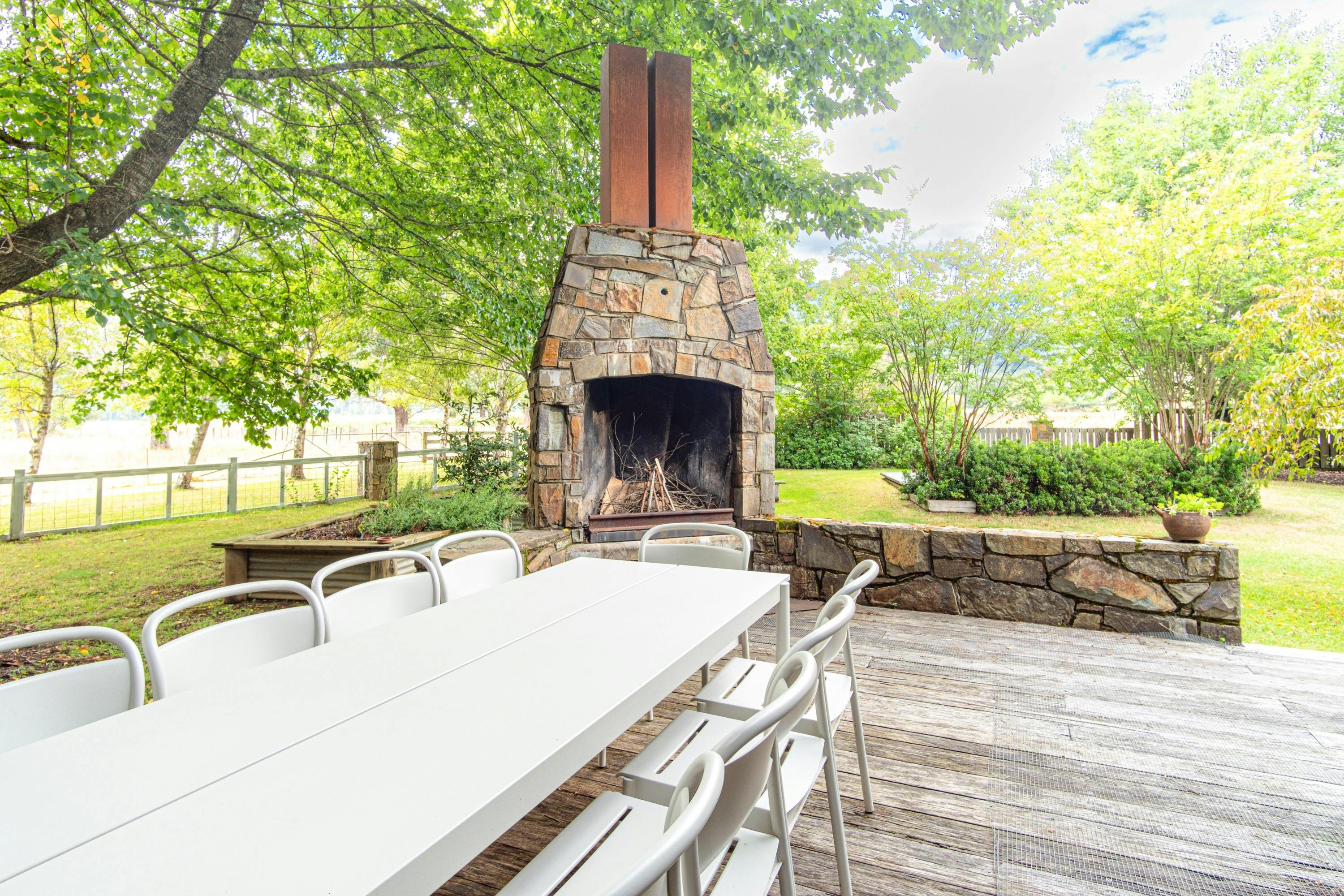 Back alfresco area with outdoor fireplace, trampoline and mountain views