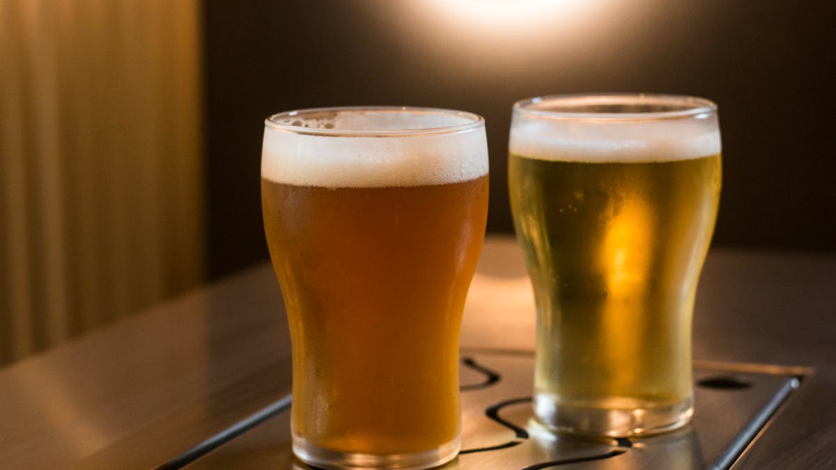 Two beers on the bar featuring the brewery logo