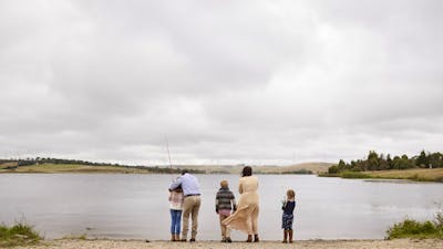 Family of four people standing on he edge of Pejar Dam