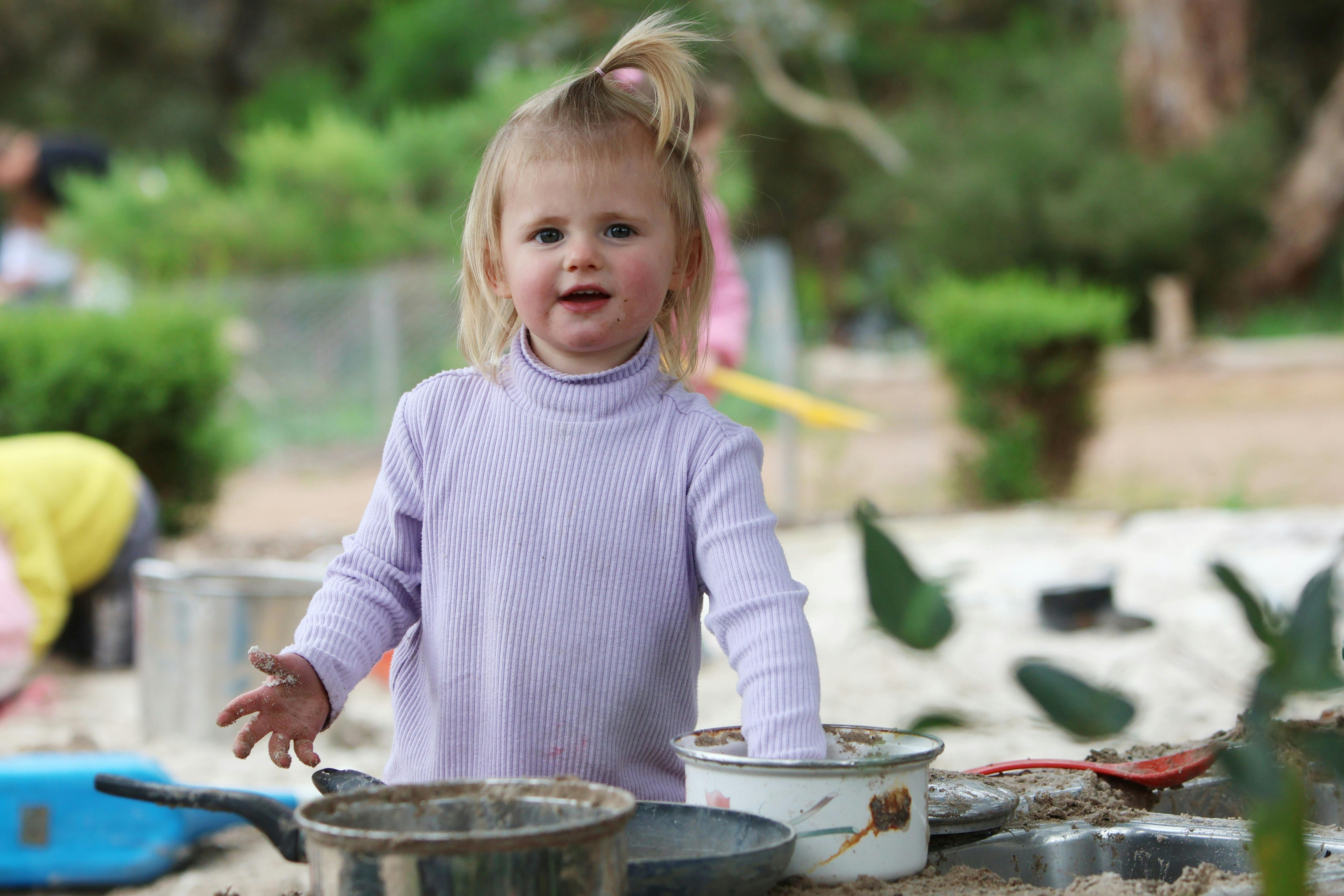 Girl playing in mud kitchen