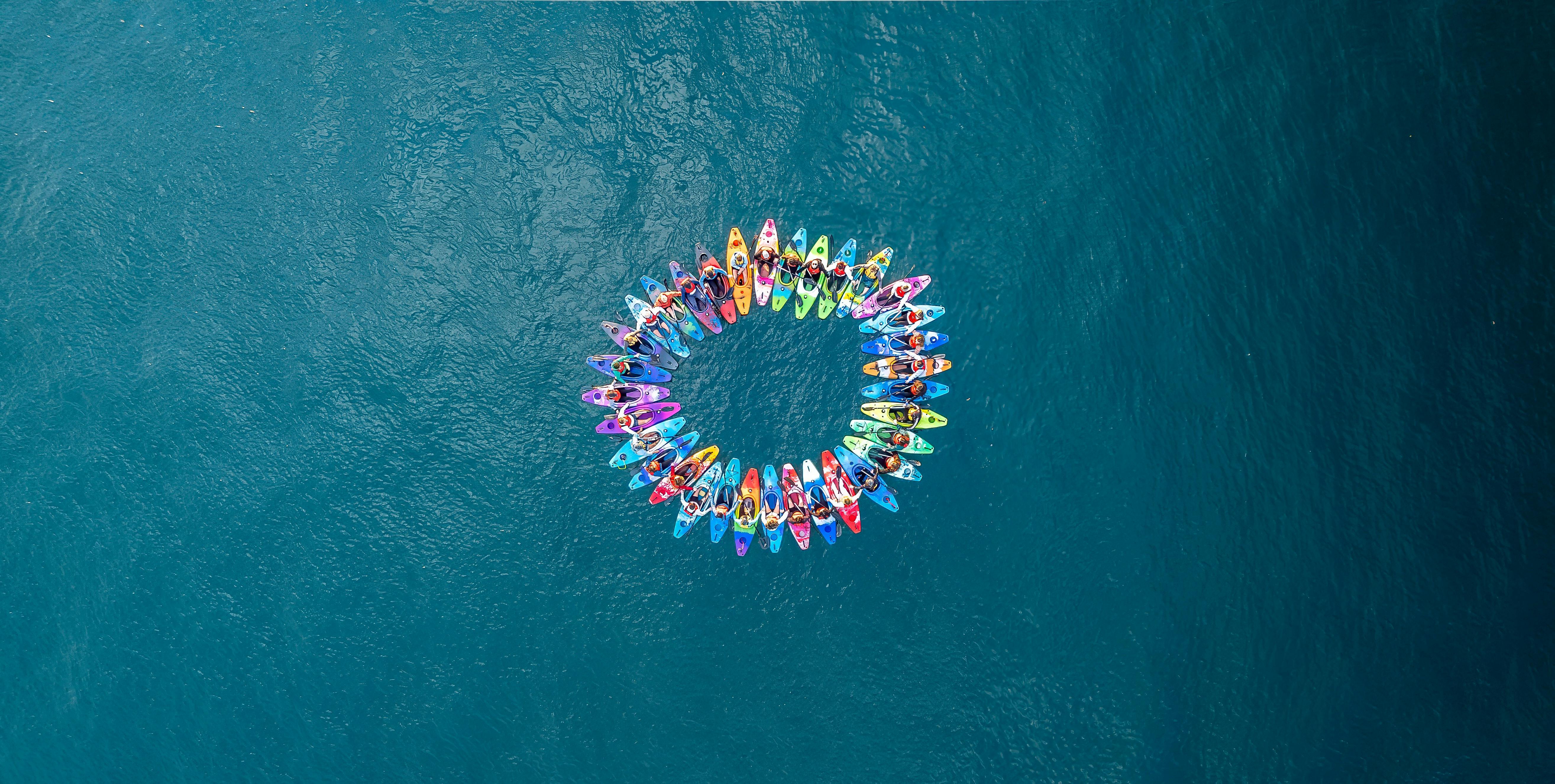A circle of colourful kayaks on the Sydney By Kayak Highlights Tour where guests see Opera House.