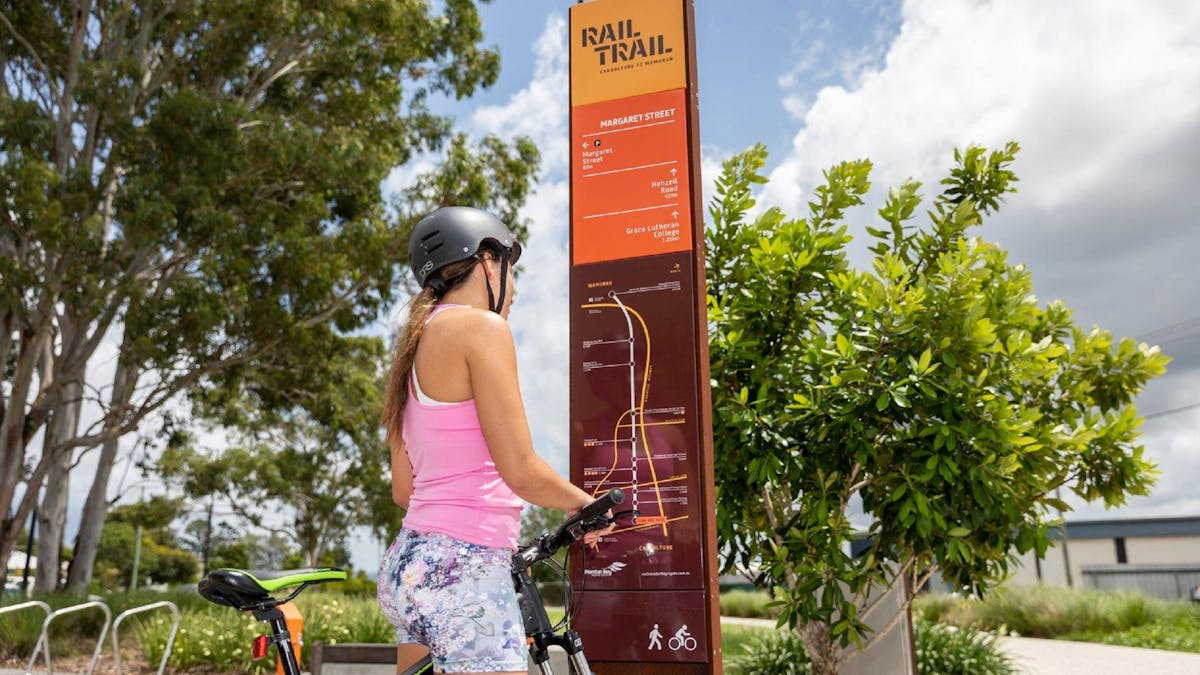 A girl looking at the map of the Caboolture to Wamuran Rail Trail