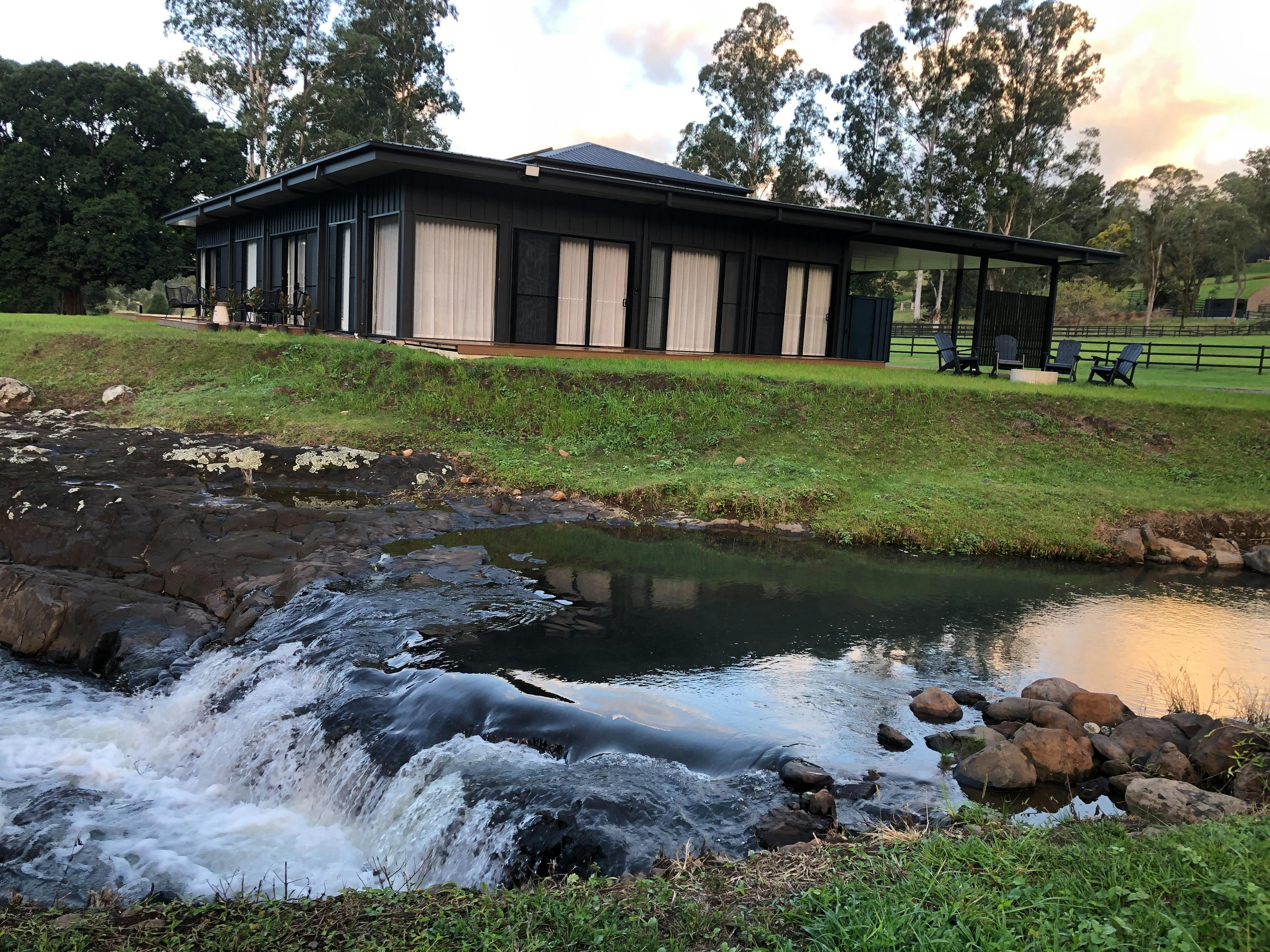 전경에 폭포처럼 물이 쏟아지는 검은색 건물