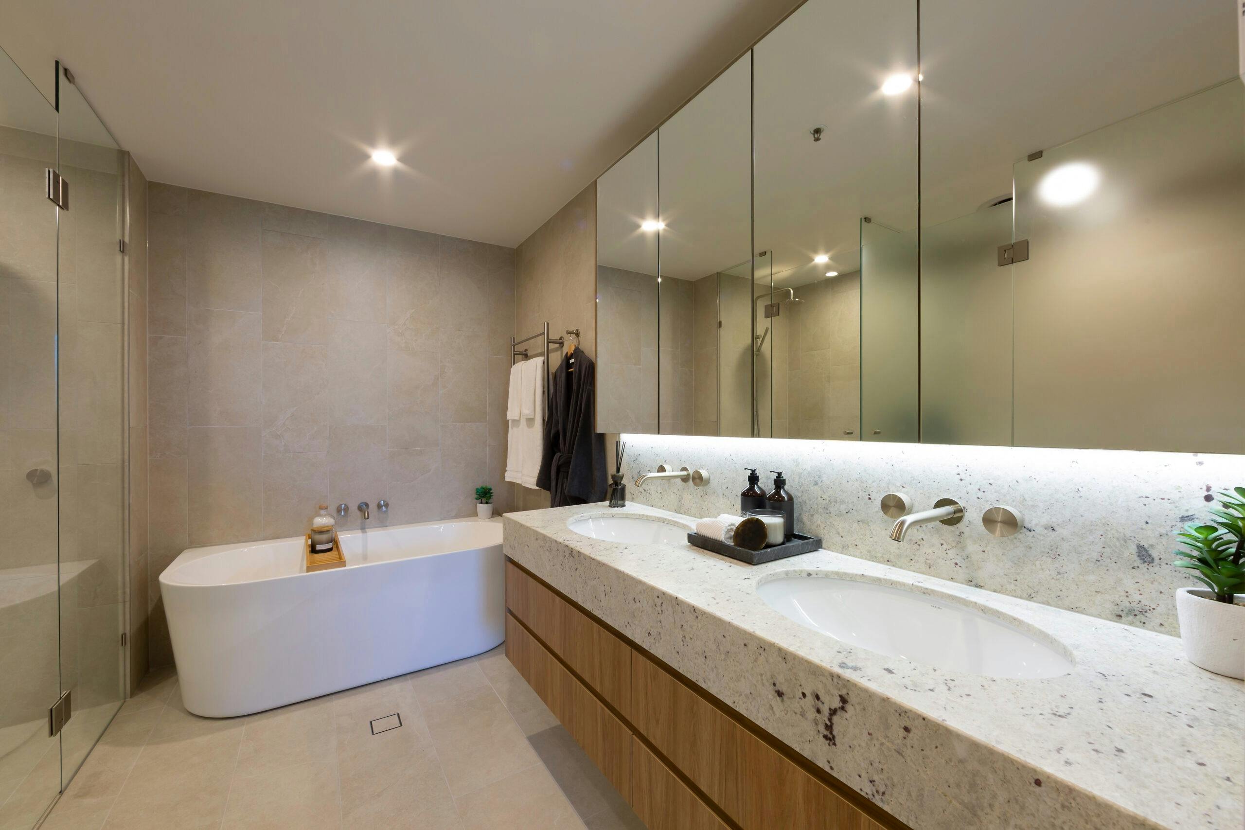 Bright apartment bathroom with a white bathtub, tiled walls, and updated fixtures.