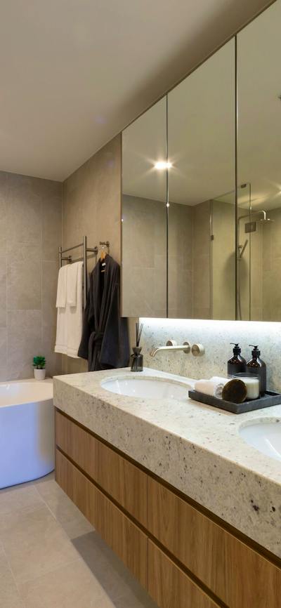 Bright apartment bathroom with a white bathtub, tiled walls, and updated fixtures.