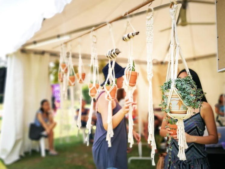 market stall with plants hanging from the roof of a gazebo