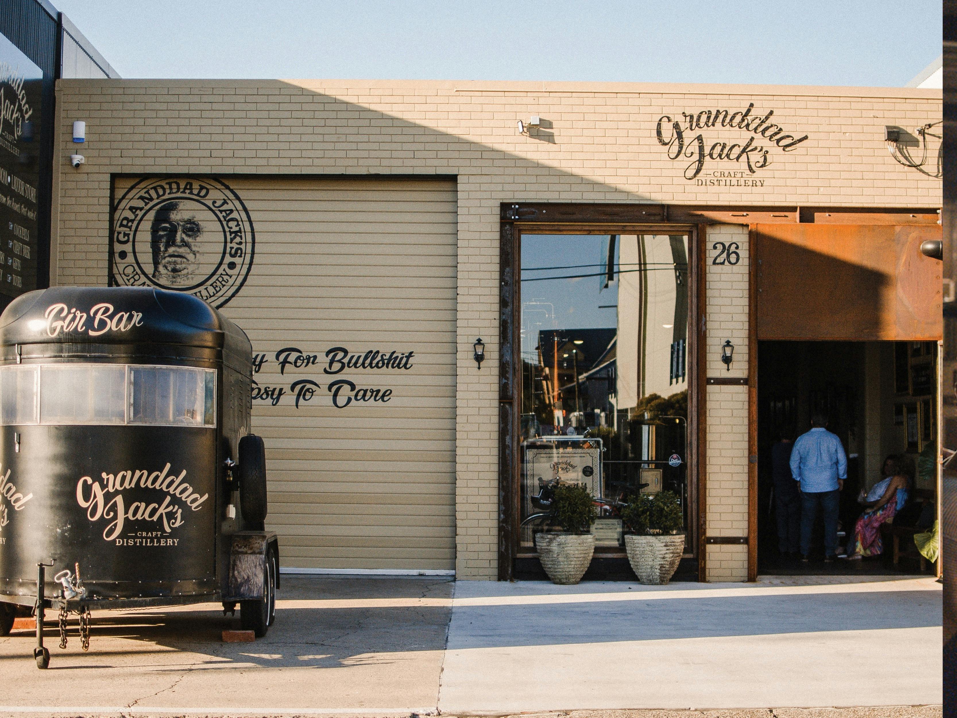 A photo of the front of the Albion, Brisbane distillery showing the tan building and horsefloat.
