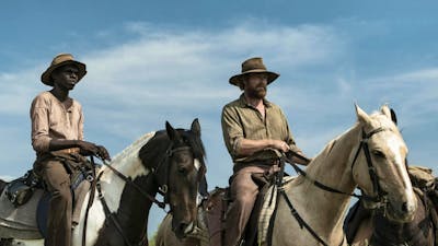 Two men on horseback in a field