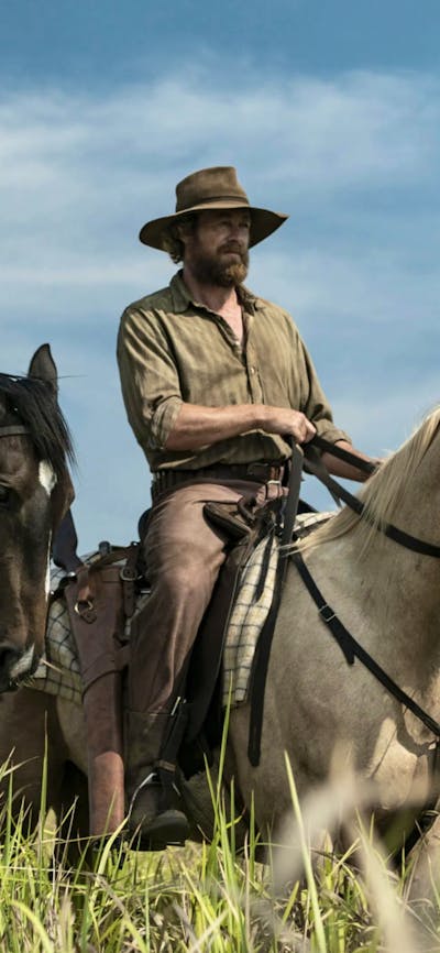 Two men on horseback in a field