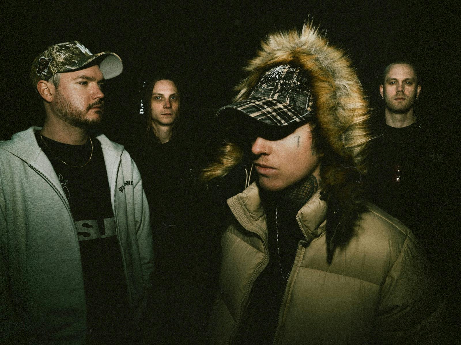 The four band members of thrown in the dark looking various ways.