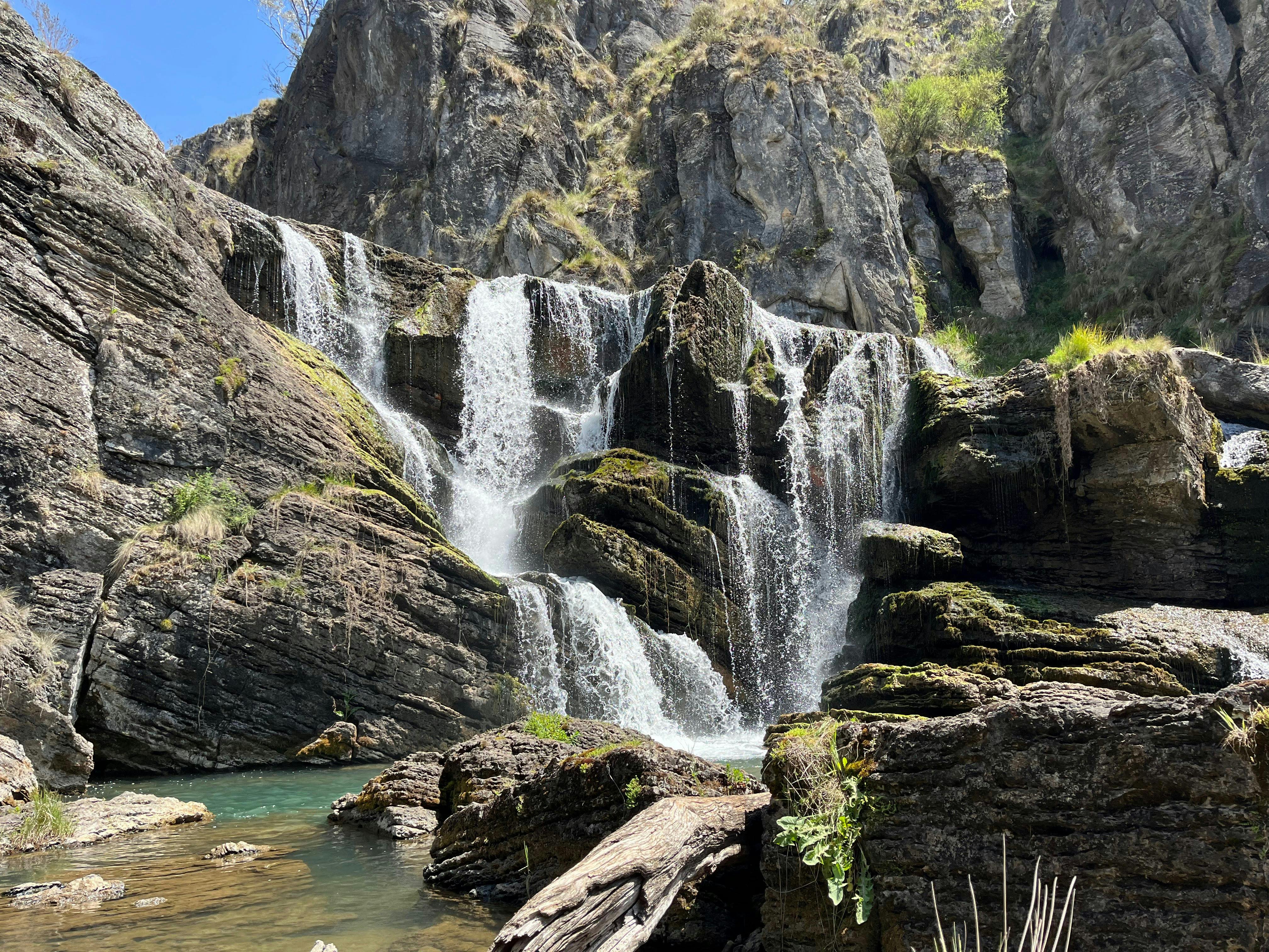 A waterfall leading into a pool of water.