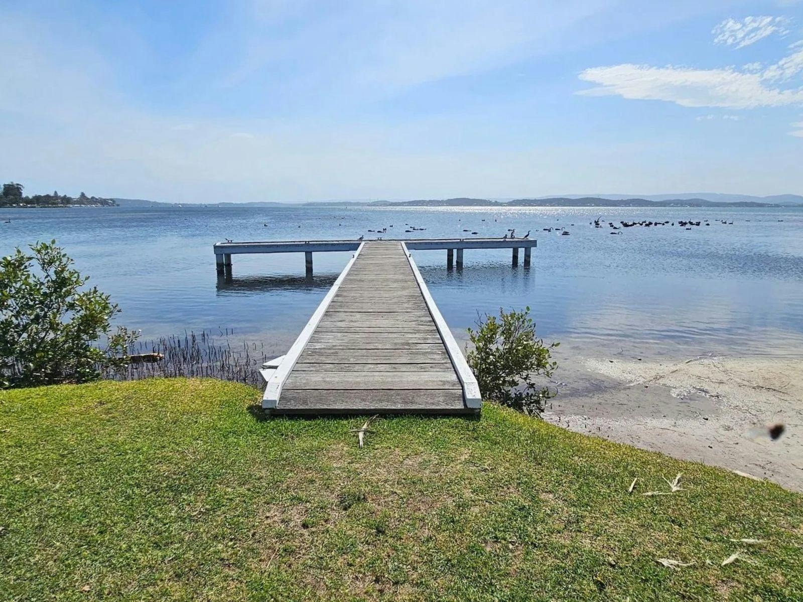 Private waterfront jetty overlooking the calm waters of Lake Macquarie, offering uninterrupted views