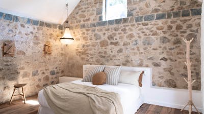 Beautiful bedroom room with stone walls and high ceiling.