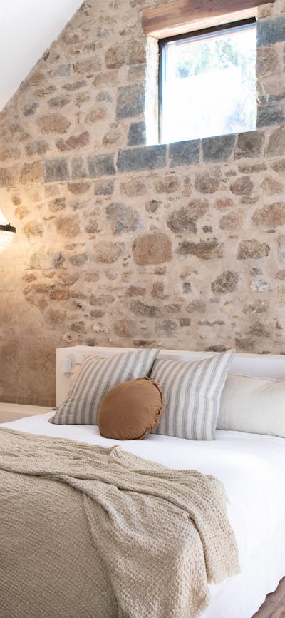 Beautiful bedroom room with stone walls and high ceiling.