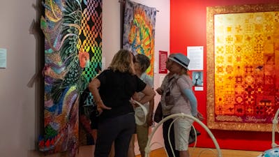 Group observing quilts at Stitching Stories