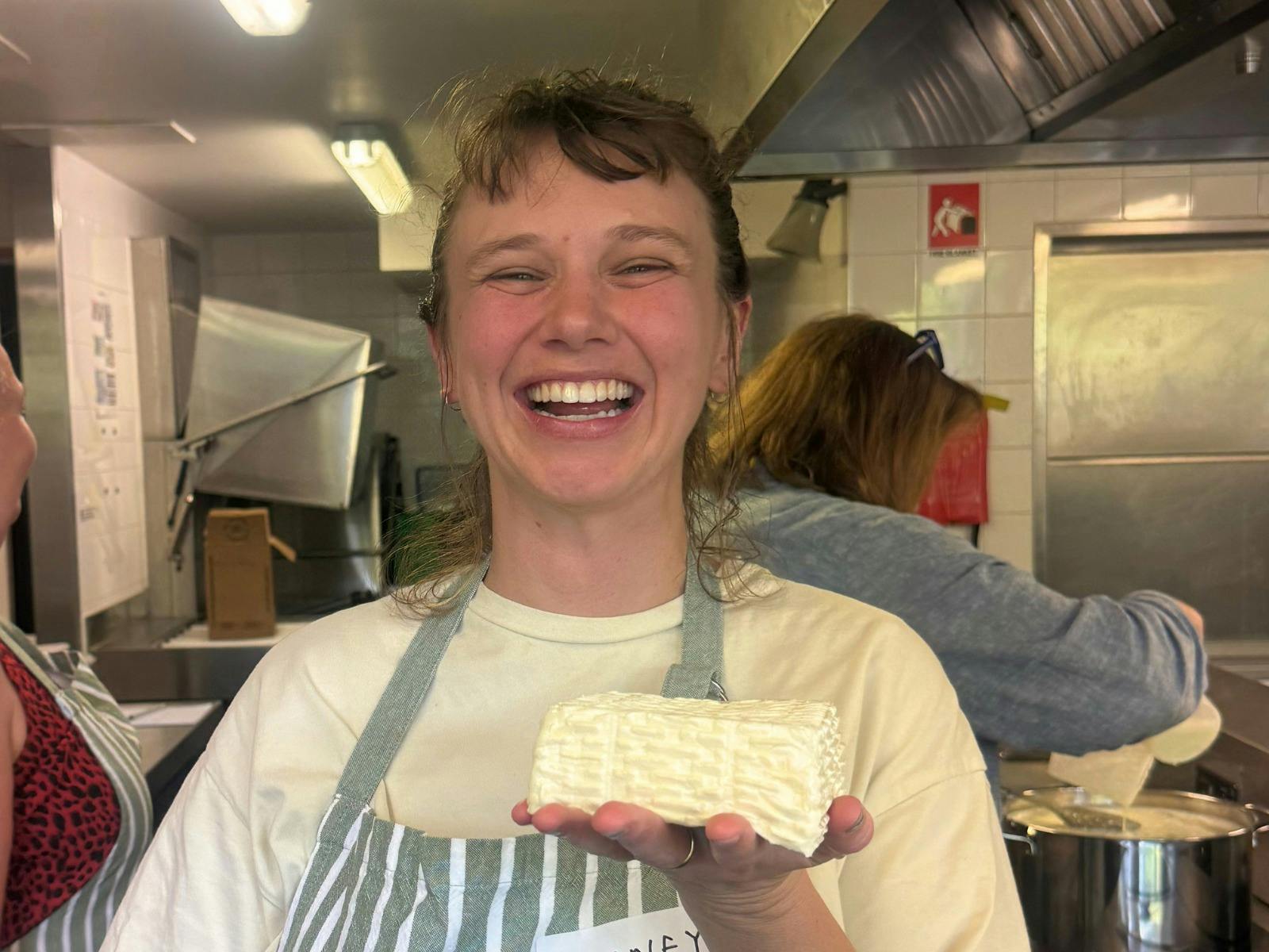 A student holds a finished block of halloumi