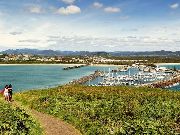 Two people enjoying the view of the Muttonbird Island Nature Reserve marina. Photo: Rob Cleary