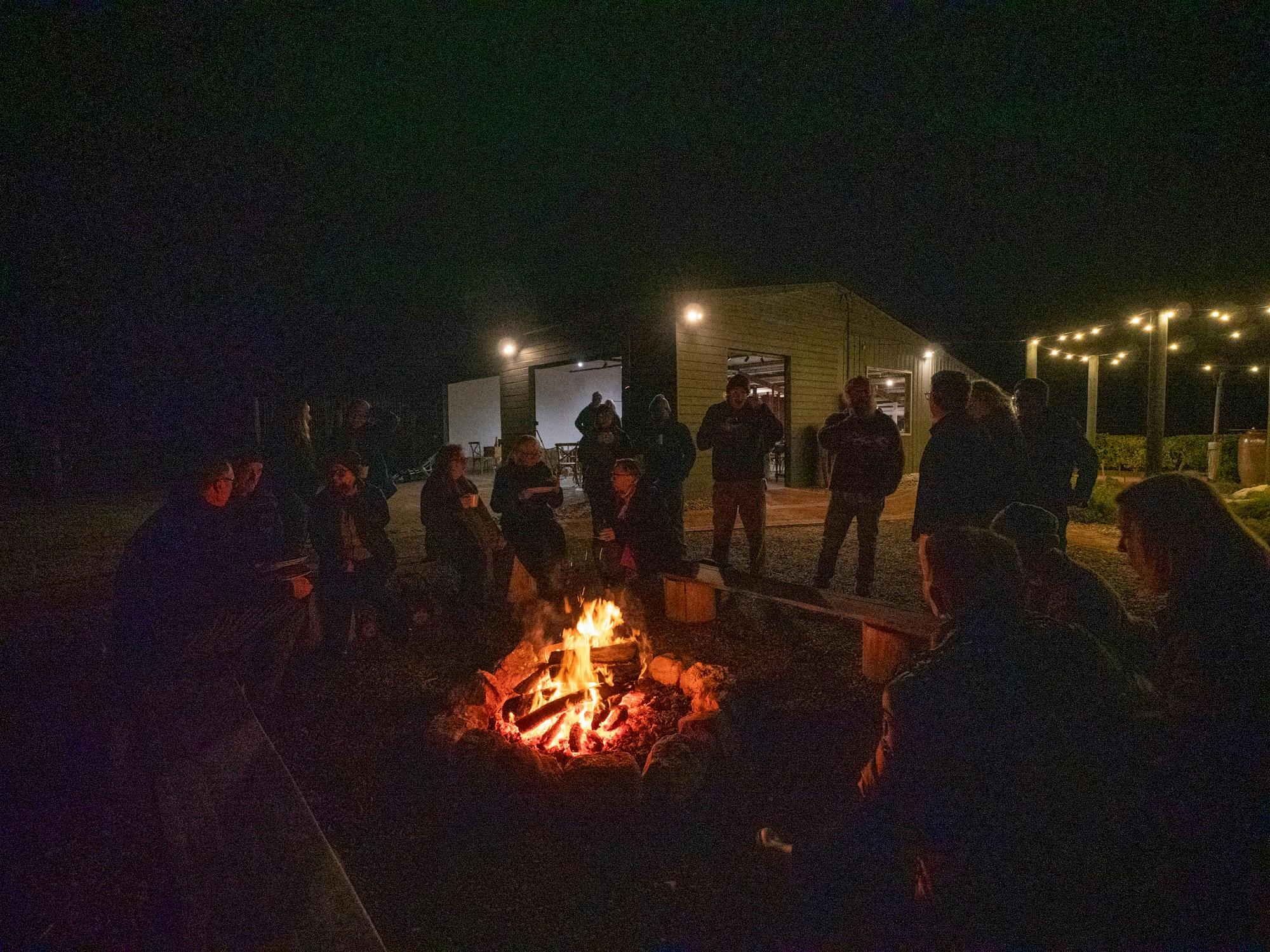 Guests enjoying dinner by open camp fire