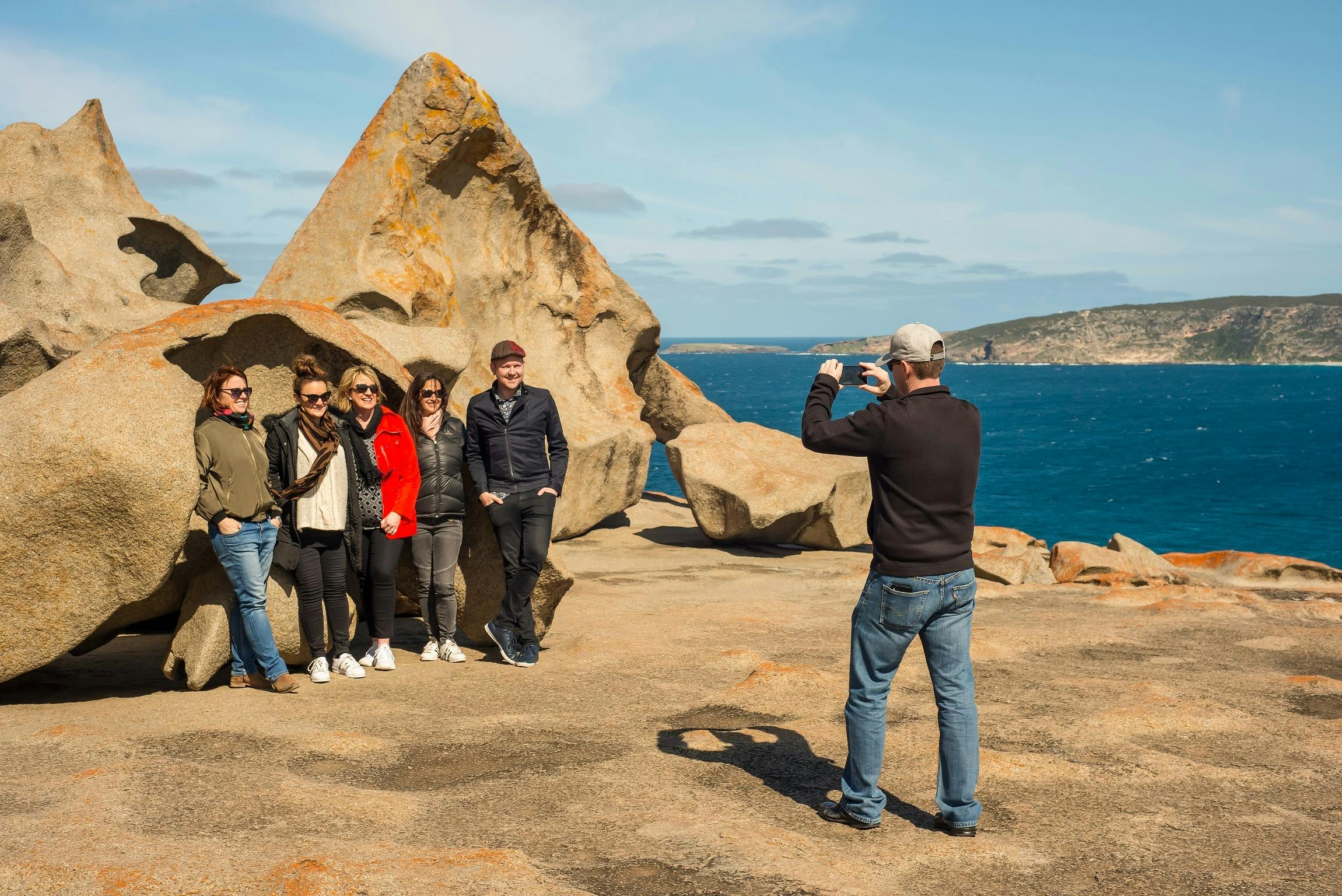 group of people having their photo taken in front of Remarkable Rocks