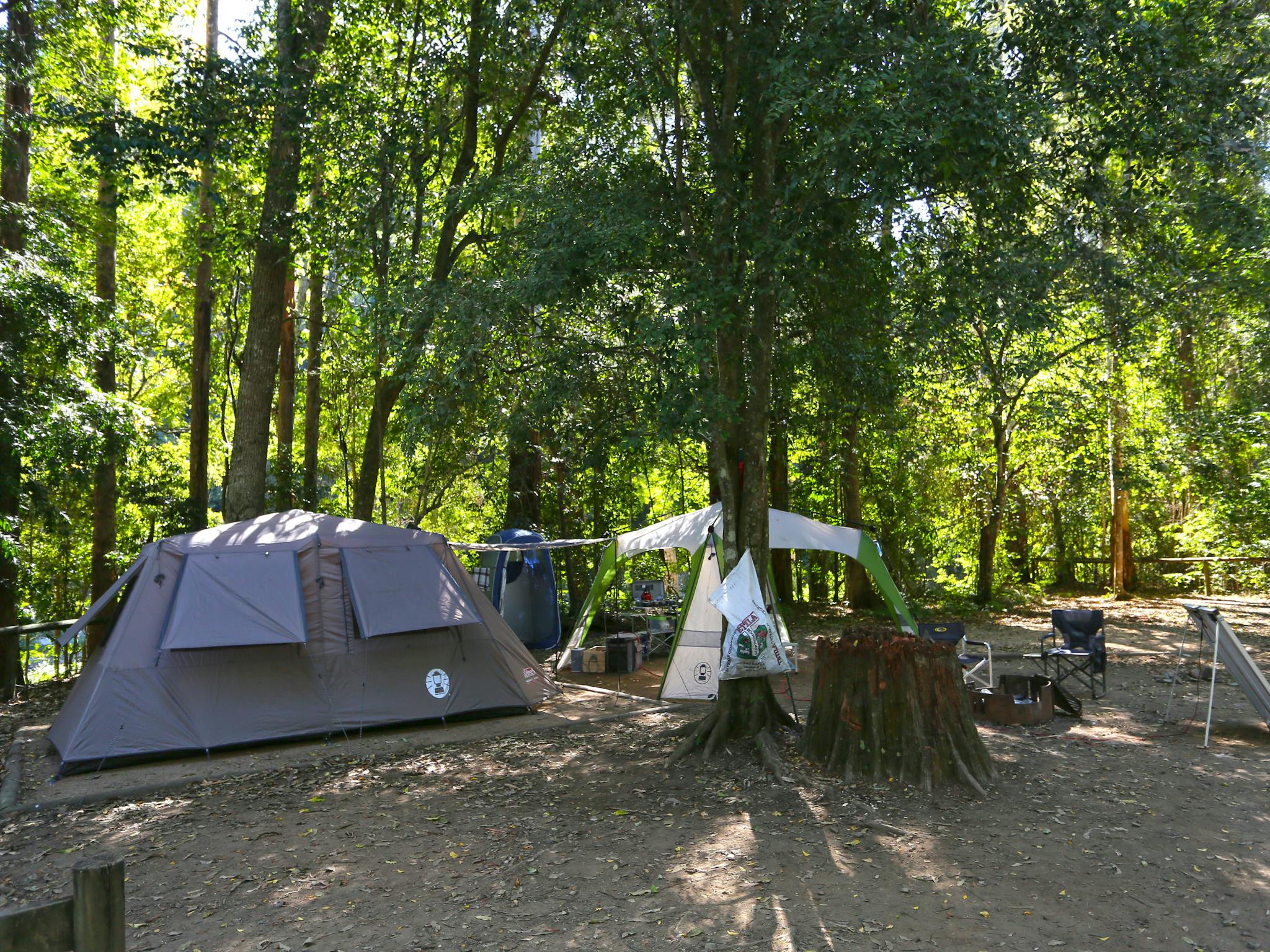 Tent and gazebo set up at camping area under shade of trees. Tent and gazebo set up at camping area under shade of trees.