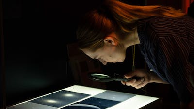 Person exploring glass plates with stars in Outer Space exhibition