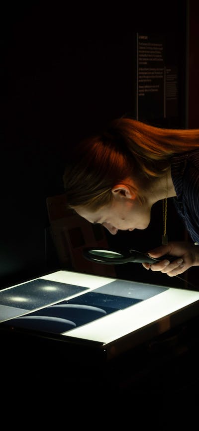 Person exploring glass plates with stars in Outer Space exhibition