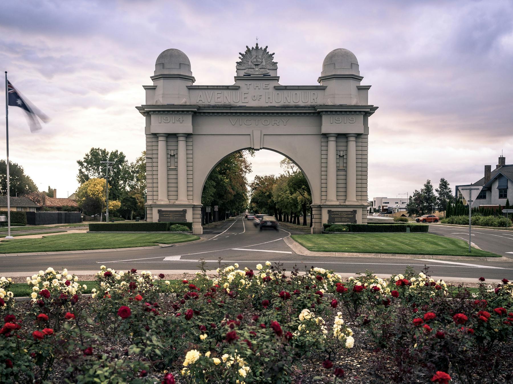 Front view of the Arch of Victory, with cars driving though