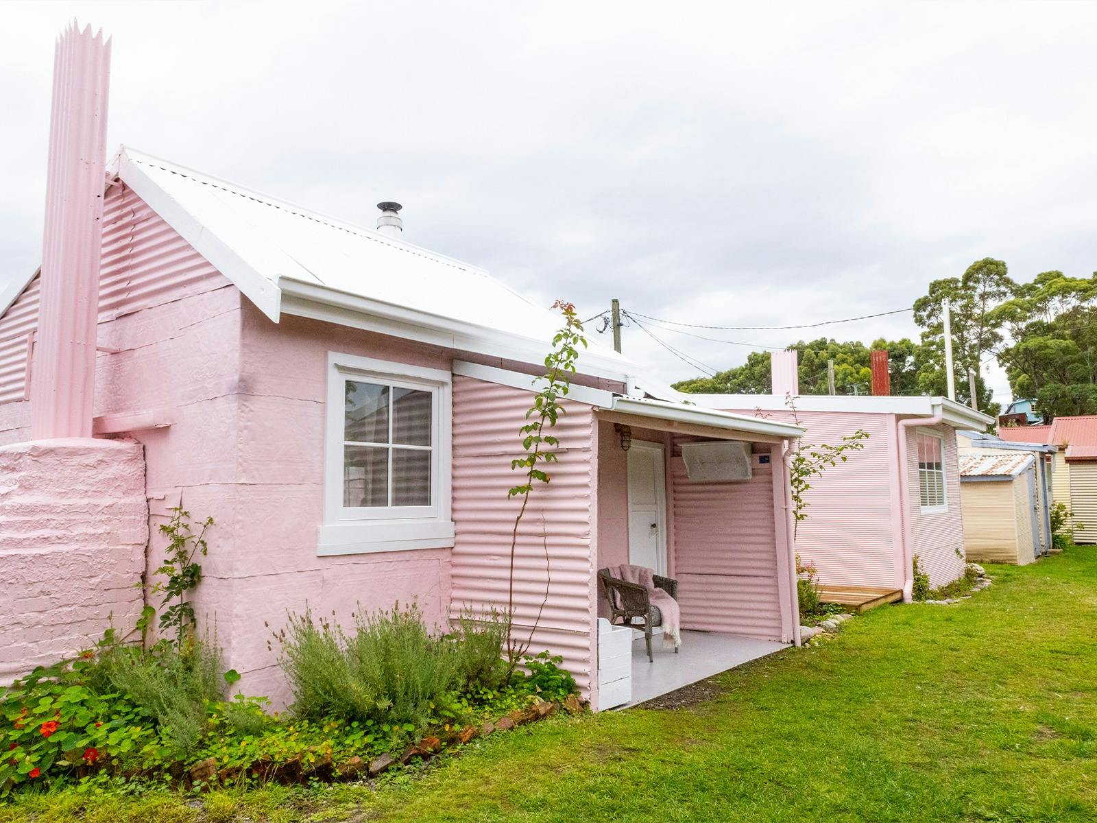 A pink shack with a white roof and windows