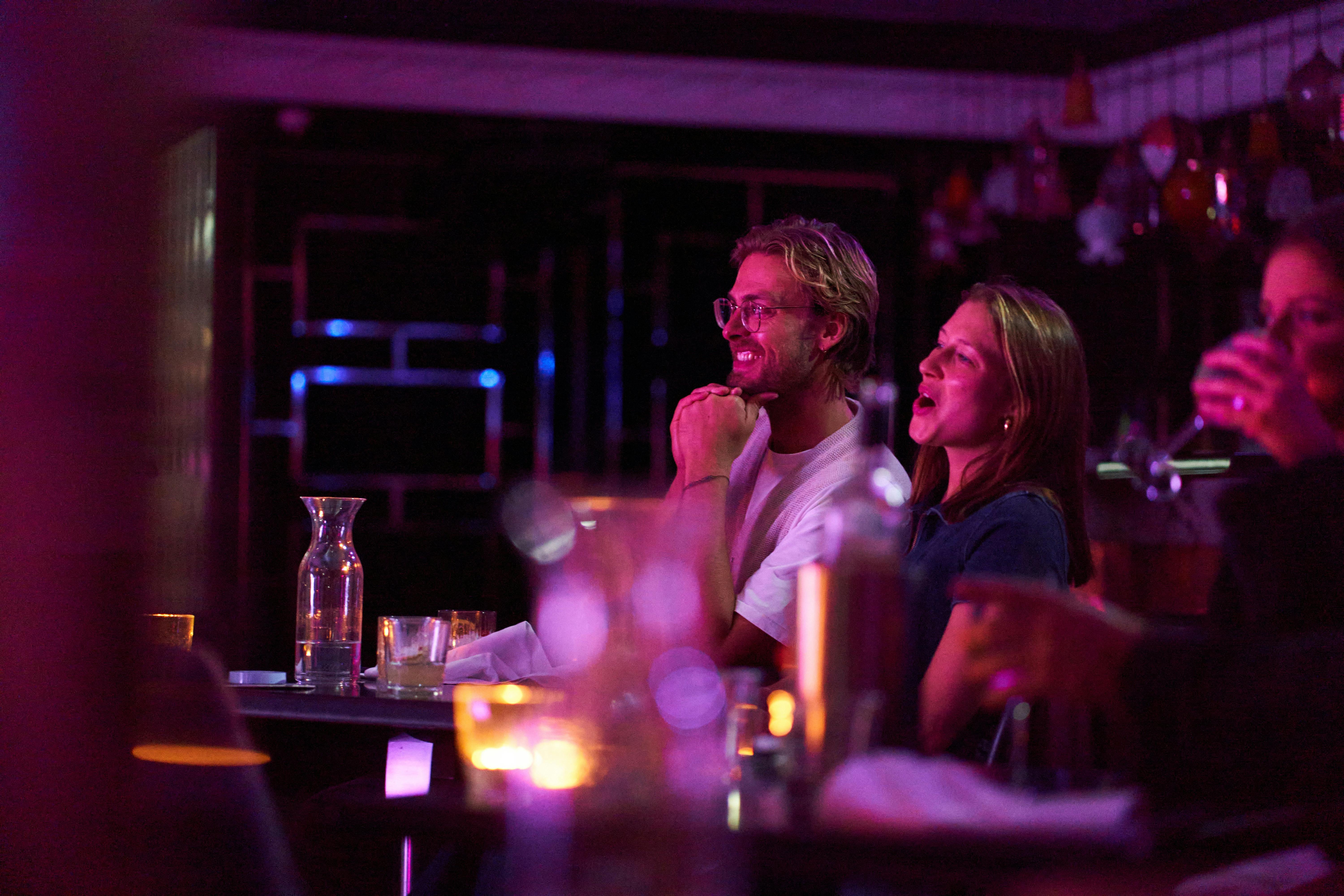 A young couple in an intimate setting watching a live show