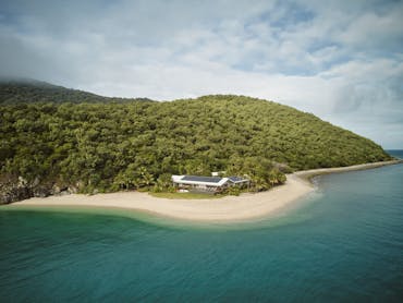 Image of private island with dense bush white sand and blue water Image of private island with dense bush white sand and blue water