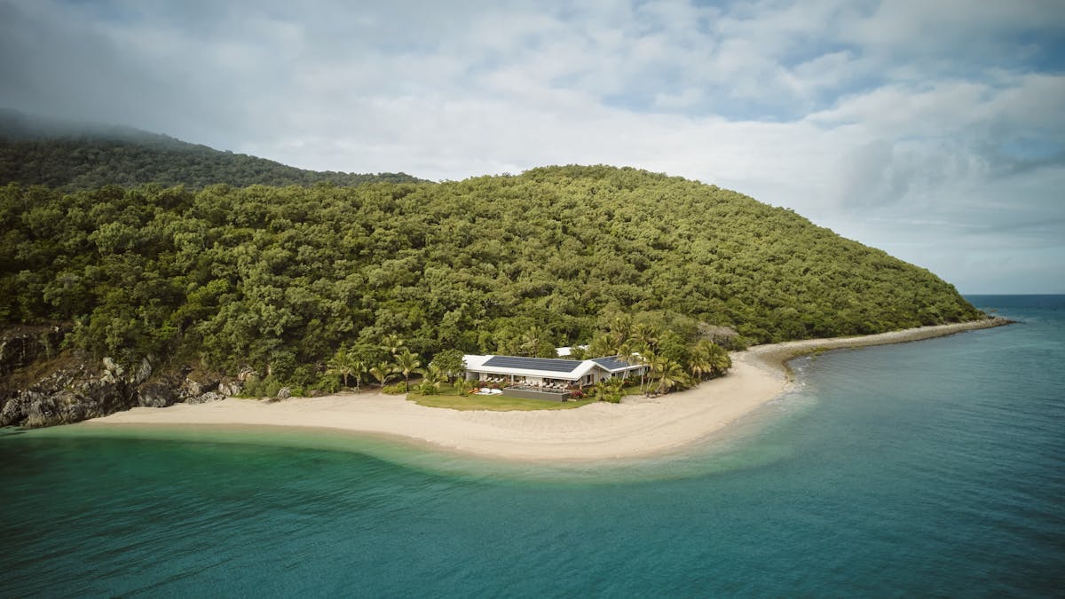 Image of private island with dense bush white sand and blue water