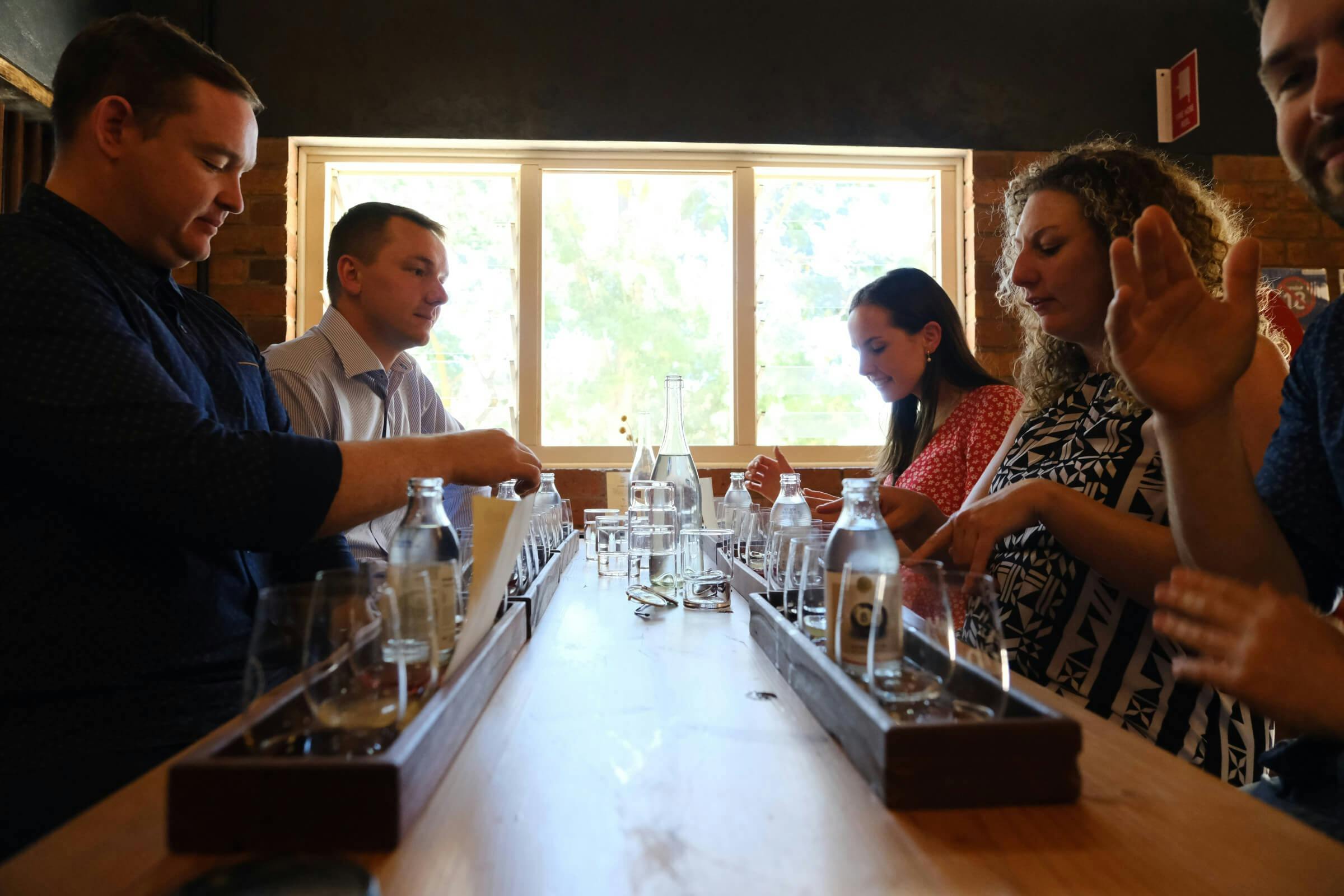 Group tour tasting gin at a high table