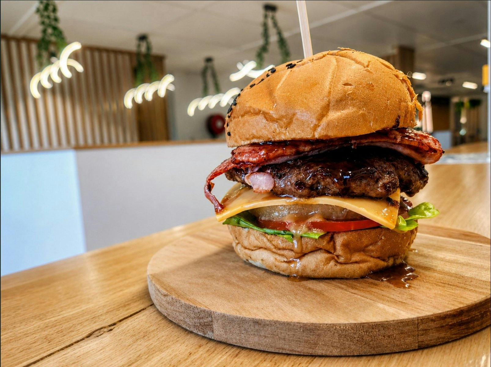 Tropical beef burger with bacon, pineapple, cheese, tomato, lettuce and burger sauce.