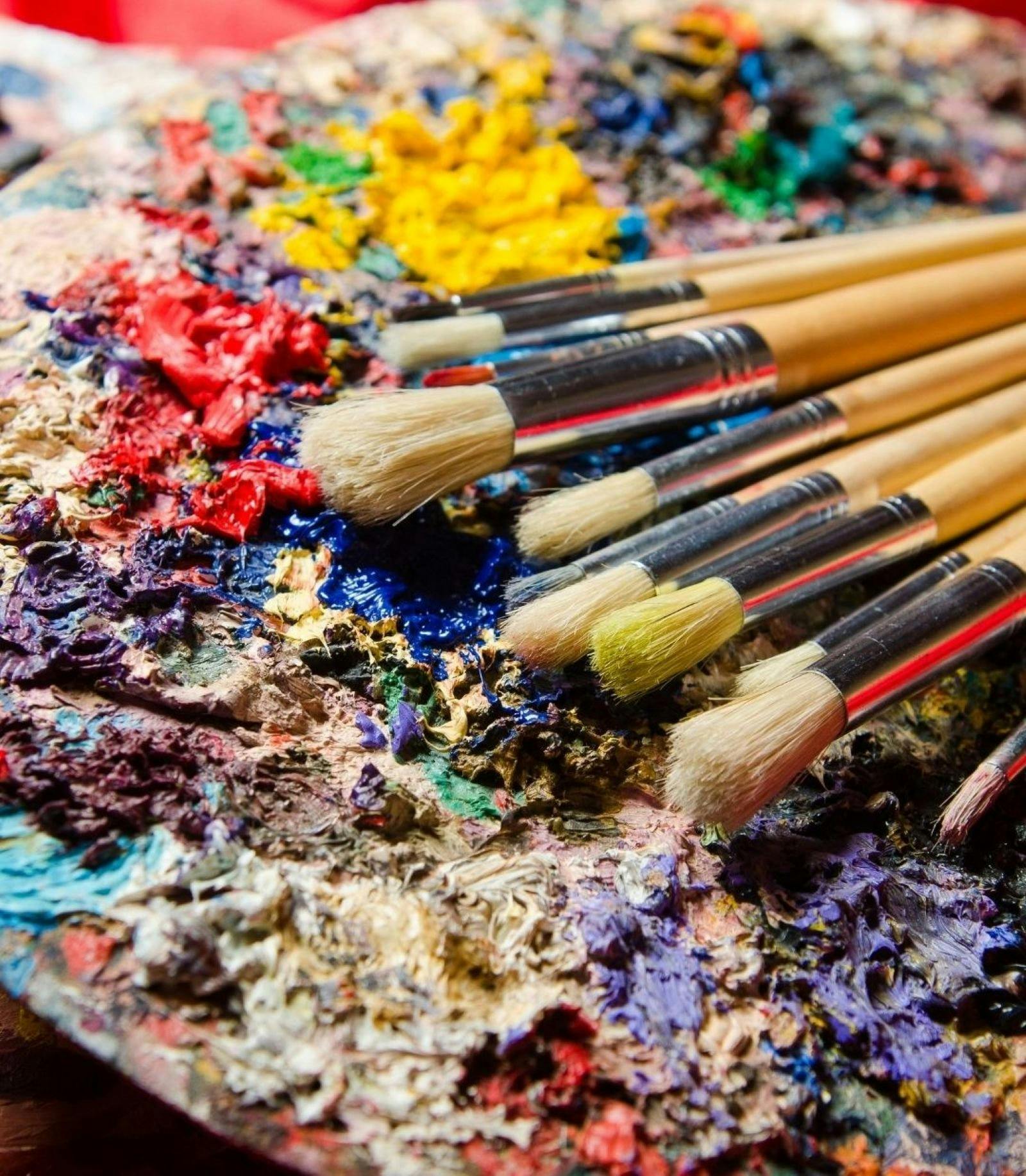 paintbrushes on a well used paint easel