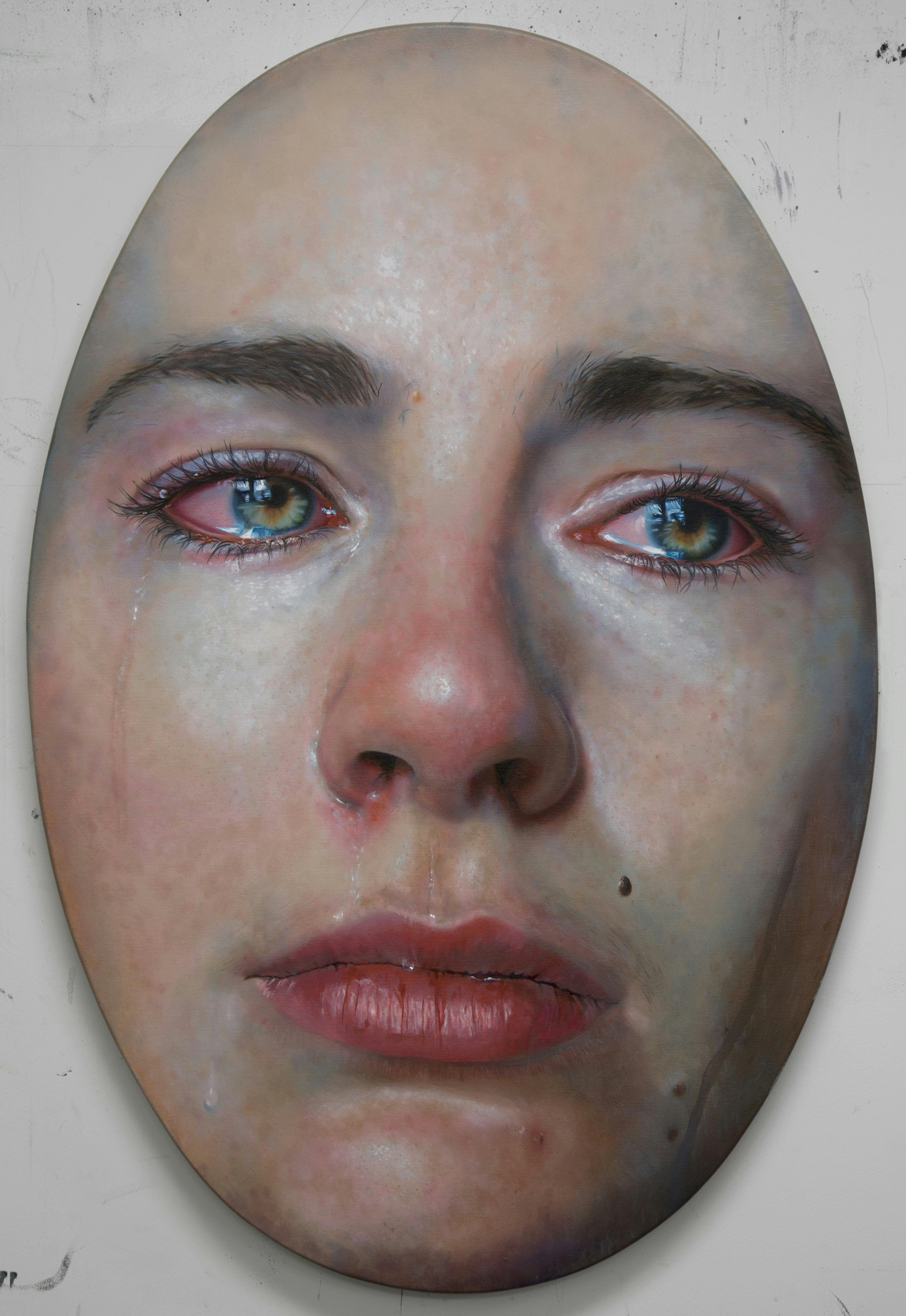 An highly detailed image of a woman's face crying in hyper realism on an oval canvas.