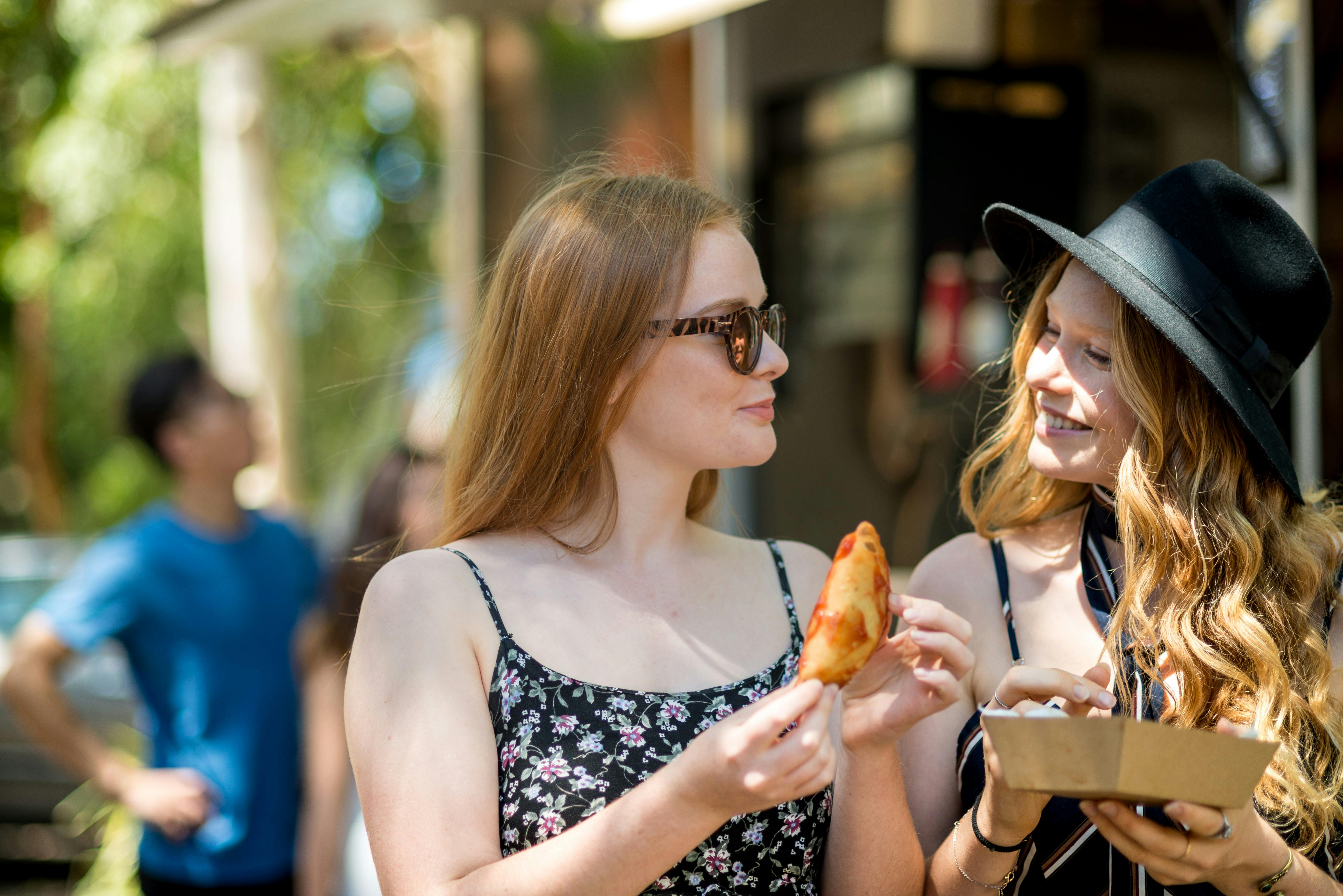 Two women enjoying delicious South American empanadas