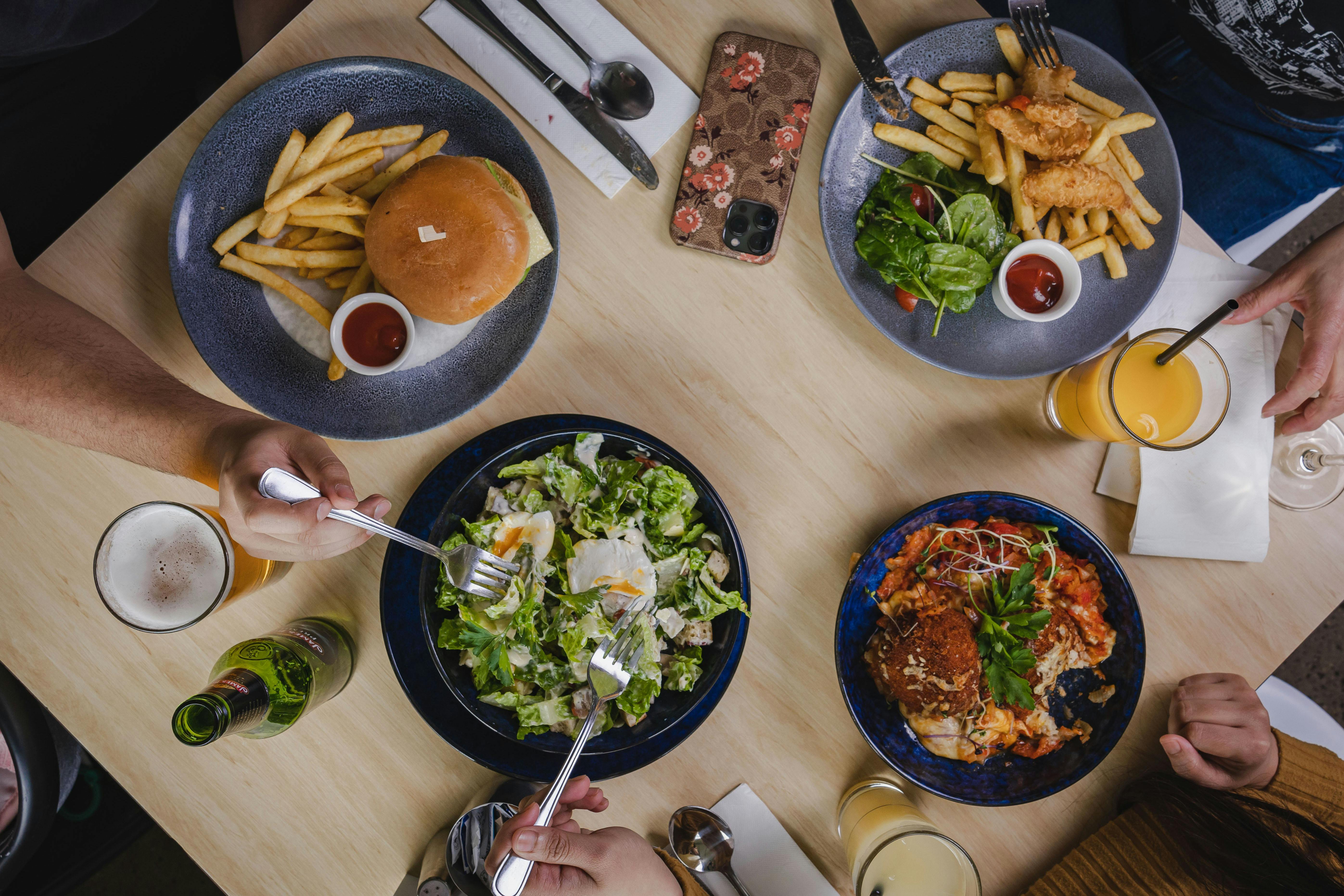 burger and chips, Caesar salad, arancini, fish and chips