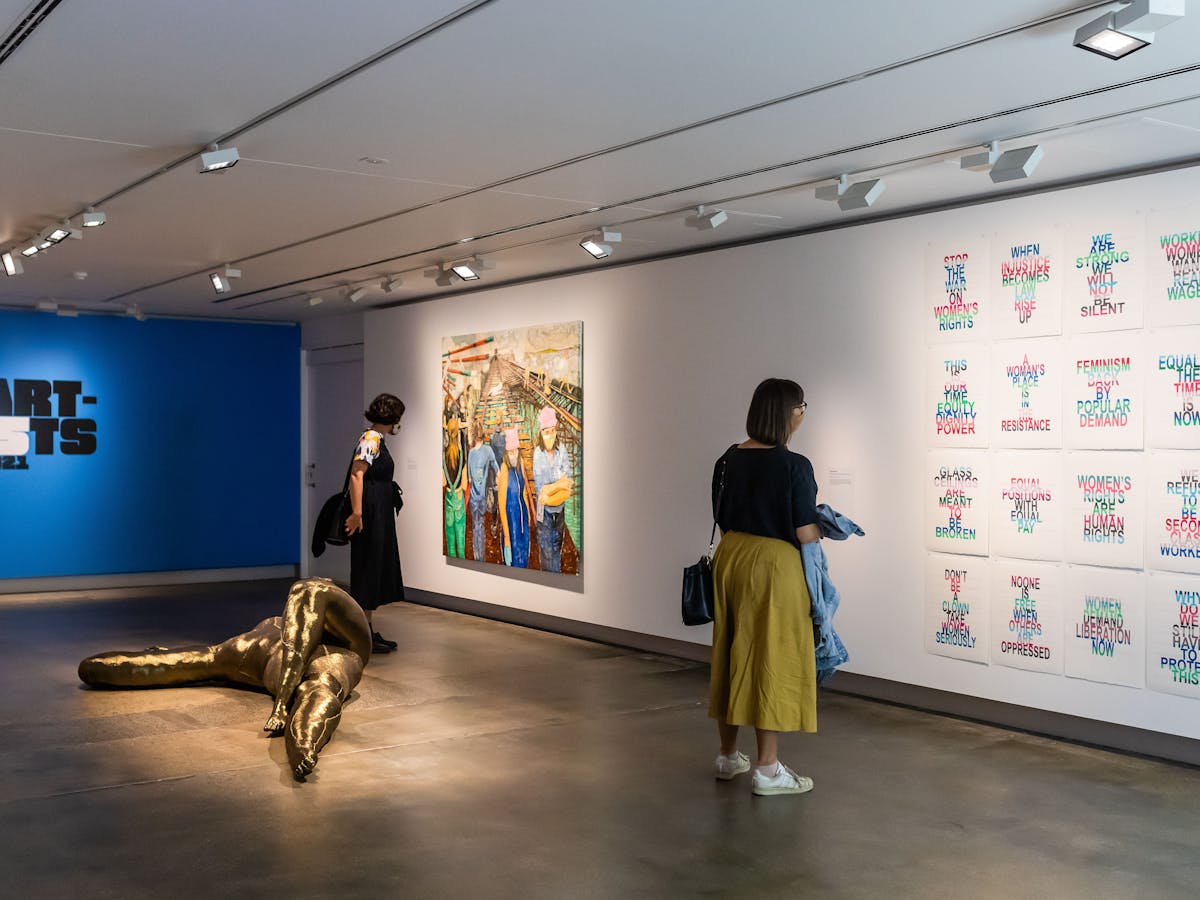 Two women viewing artwork on wall