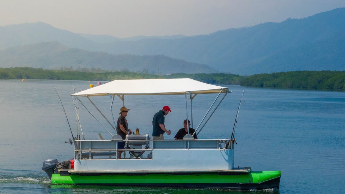 Wide shot of a Cairns Boat Hire Pontoon with 3 men fishing on the Trinity Inlet